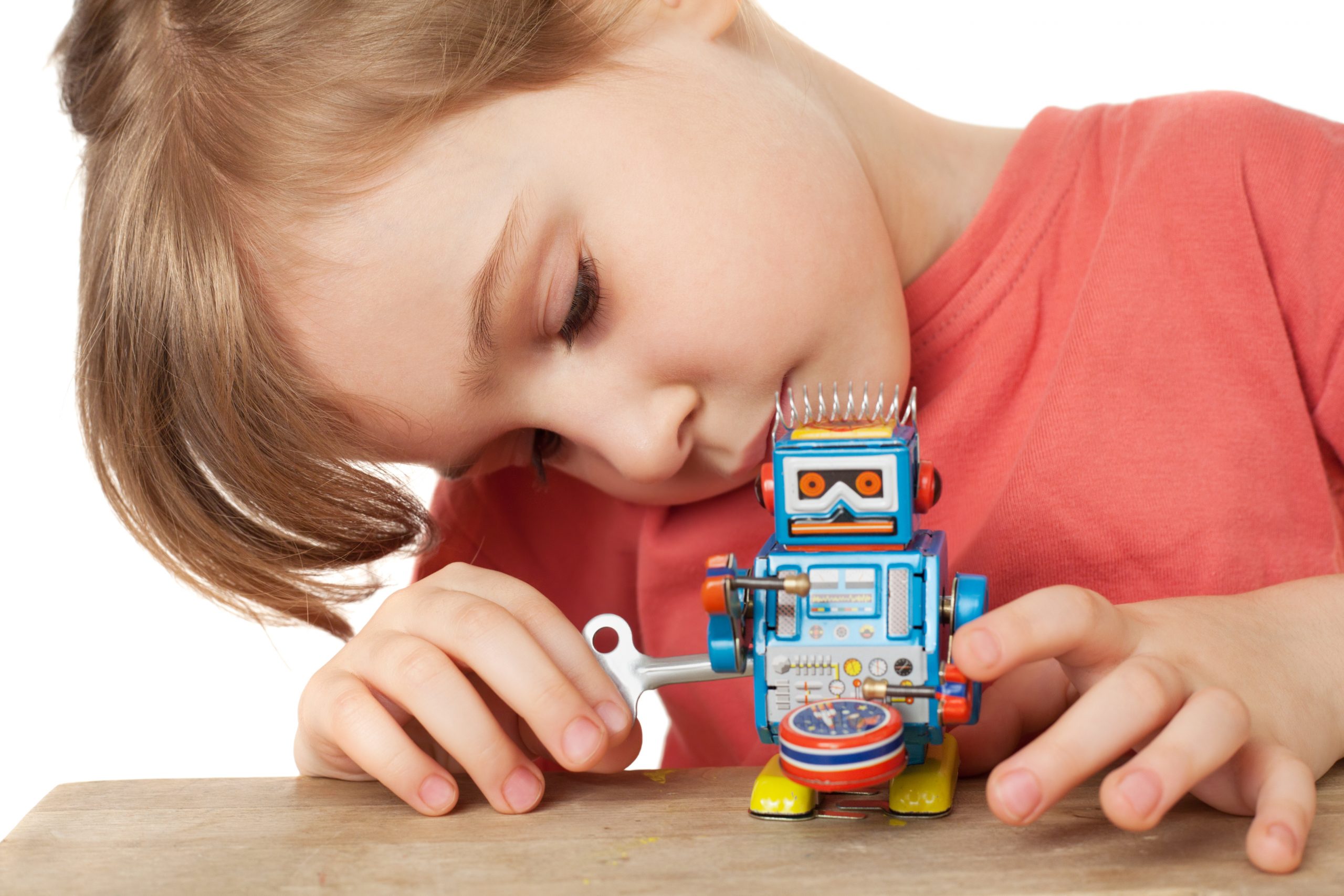 little girl in red T-shirt plays with clockwork robot isolated
